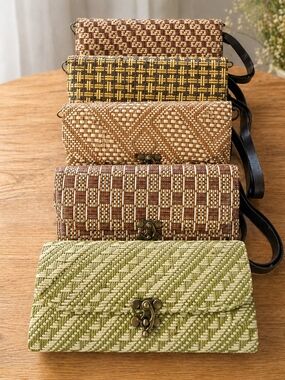 Handwoven rattan wallet clutch with a faux leather strap.